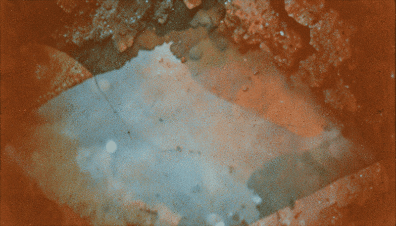 Photographie argentique granuleuse d'un ciel étoilé profond avec des nébuleuses violettes et ambrées, évoquant l'immensité de l'espace